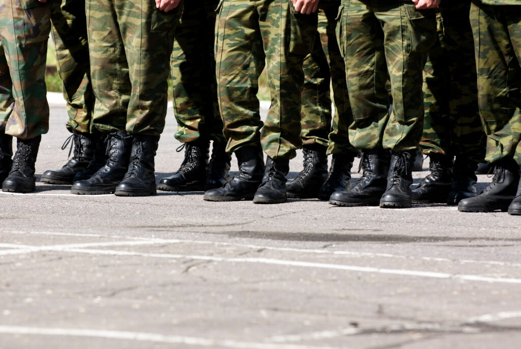 Blick auf die Beine und Füße von Soldaten, die in Militärkleidung in einer Reihe stehen