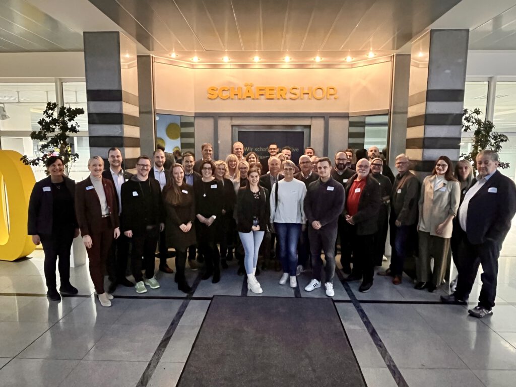 VertreterInnen der Firma Schäfer Shop, die TeilnehmerInnen der Veranstaltung und Referent Stephan Mallmann stehen in der Eingangshalle des Unternehmens.